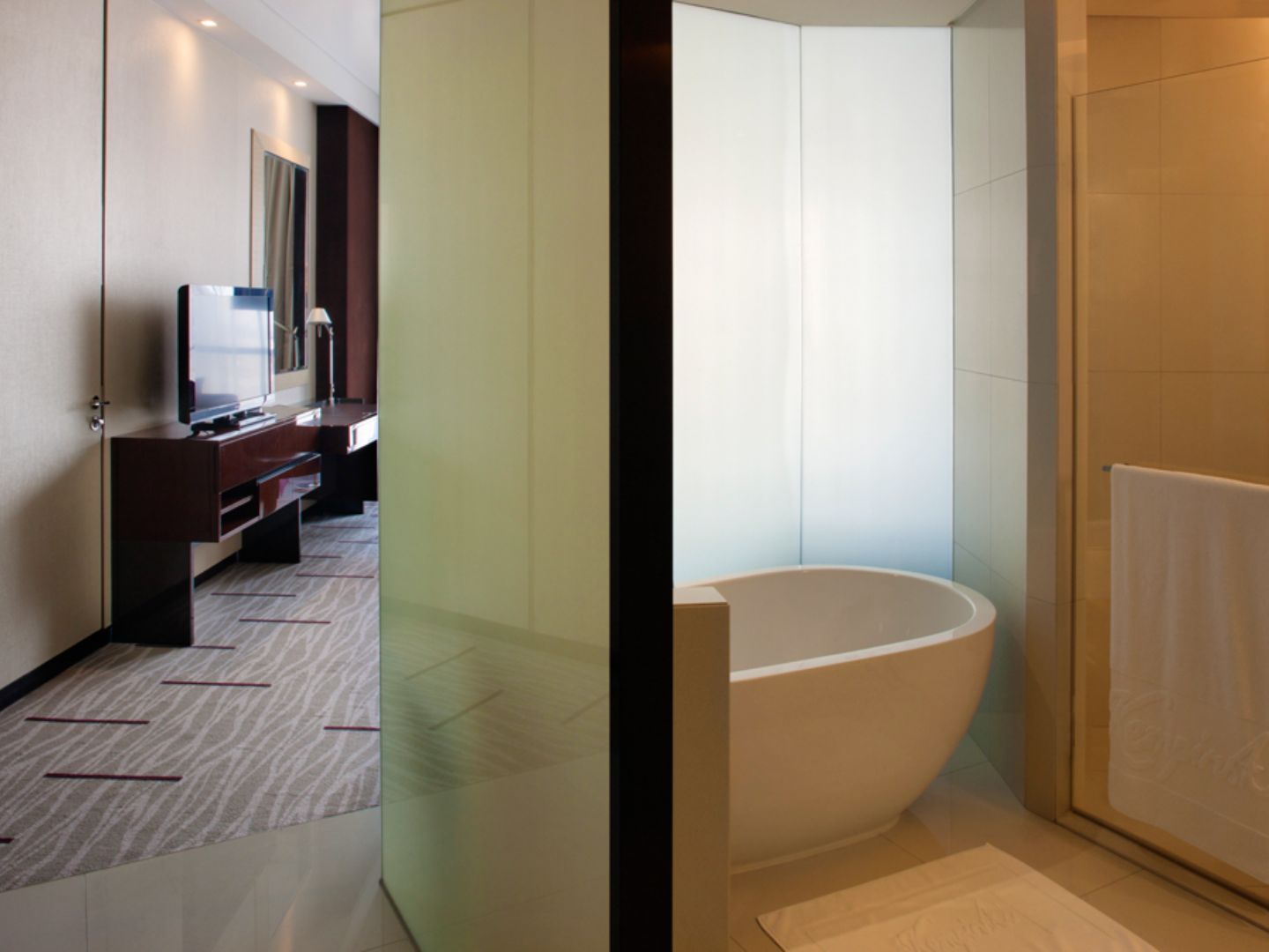 Modern hotel bathroom with freestanding white tub