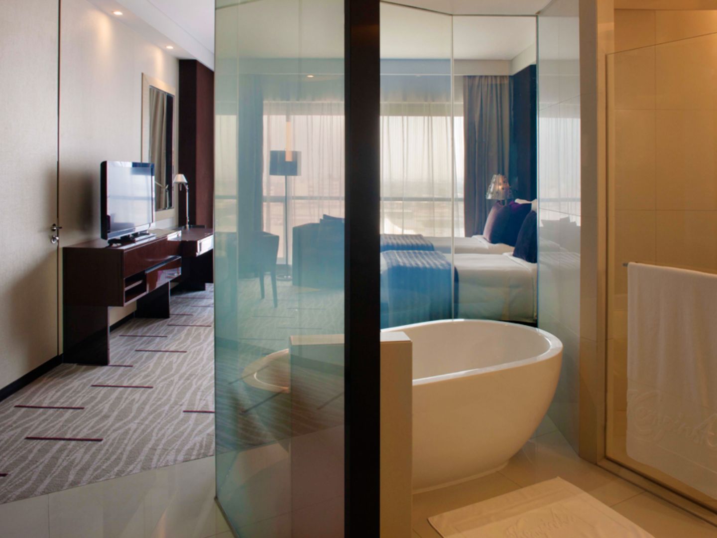 Hotel room with glass-partitioned freestanding bathtub