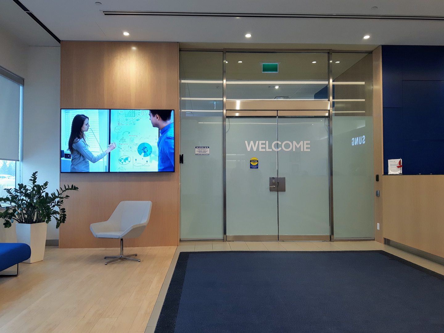 Office lobby with glass doors reading WELCOME