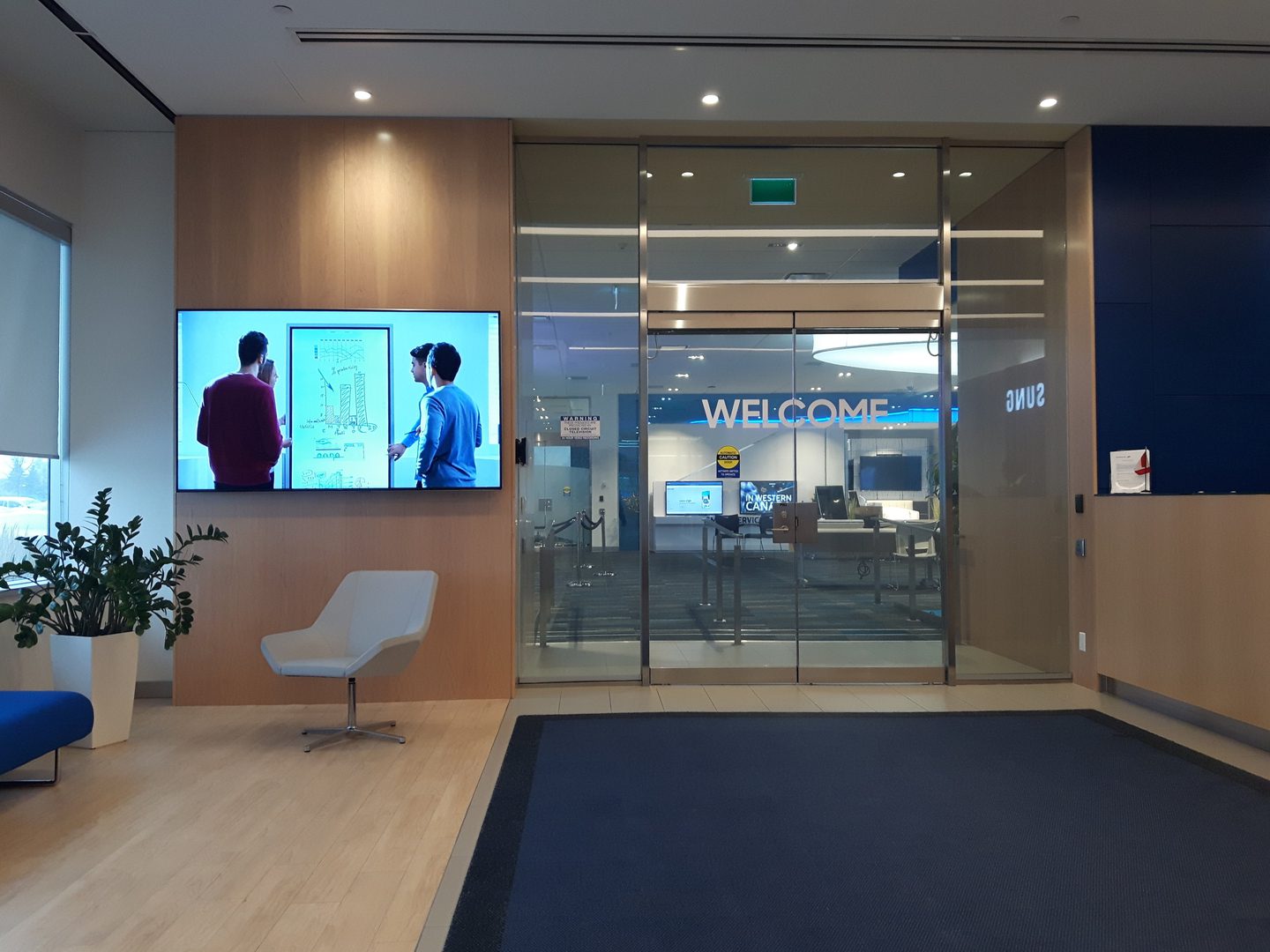 Modern lobby with glass doors and welcome sign