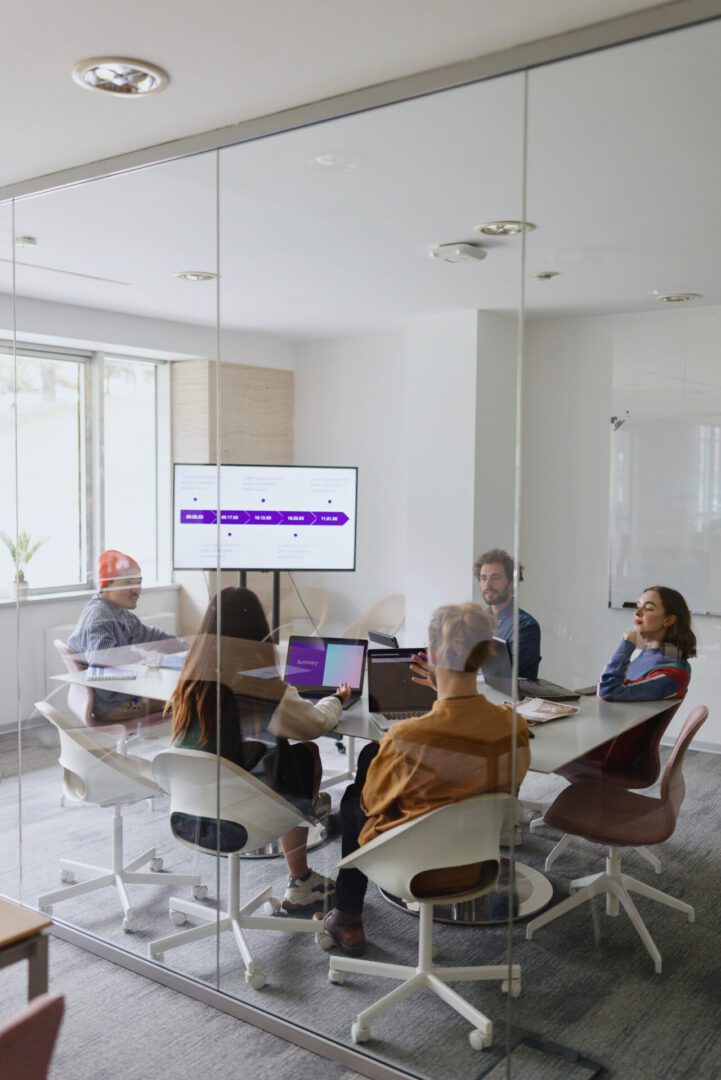 Team meeting around table in glass conference room