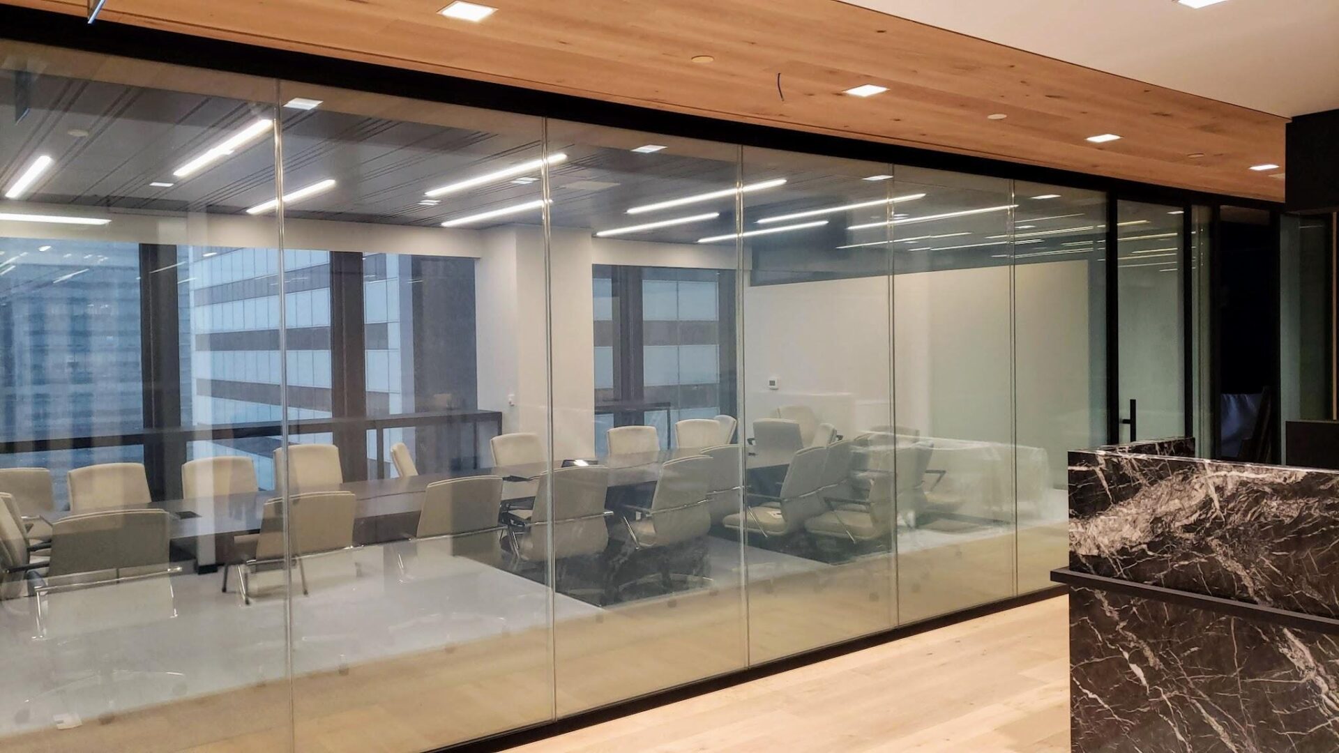 Modern glass-walled conference room with chairs