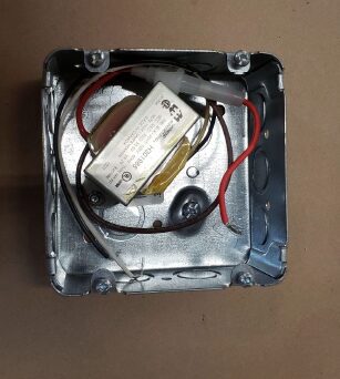 Metal junction box containing transformer and wires